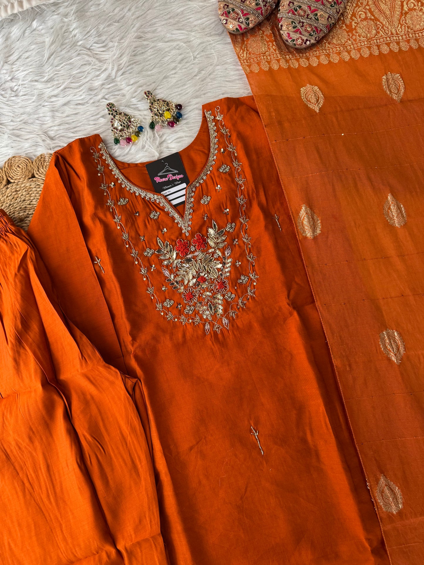 MD-189 "Embrace festive elegance in this radiant rust-orange kurta set, adorned with intricate zari embroidery and a regal Banarasi dupatta — a timeless blend of tradition and grace."