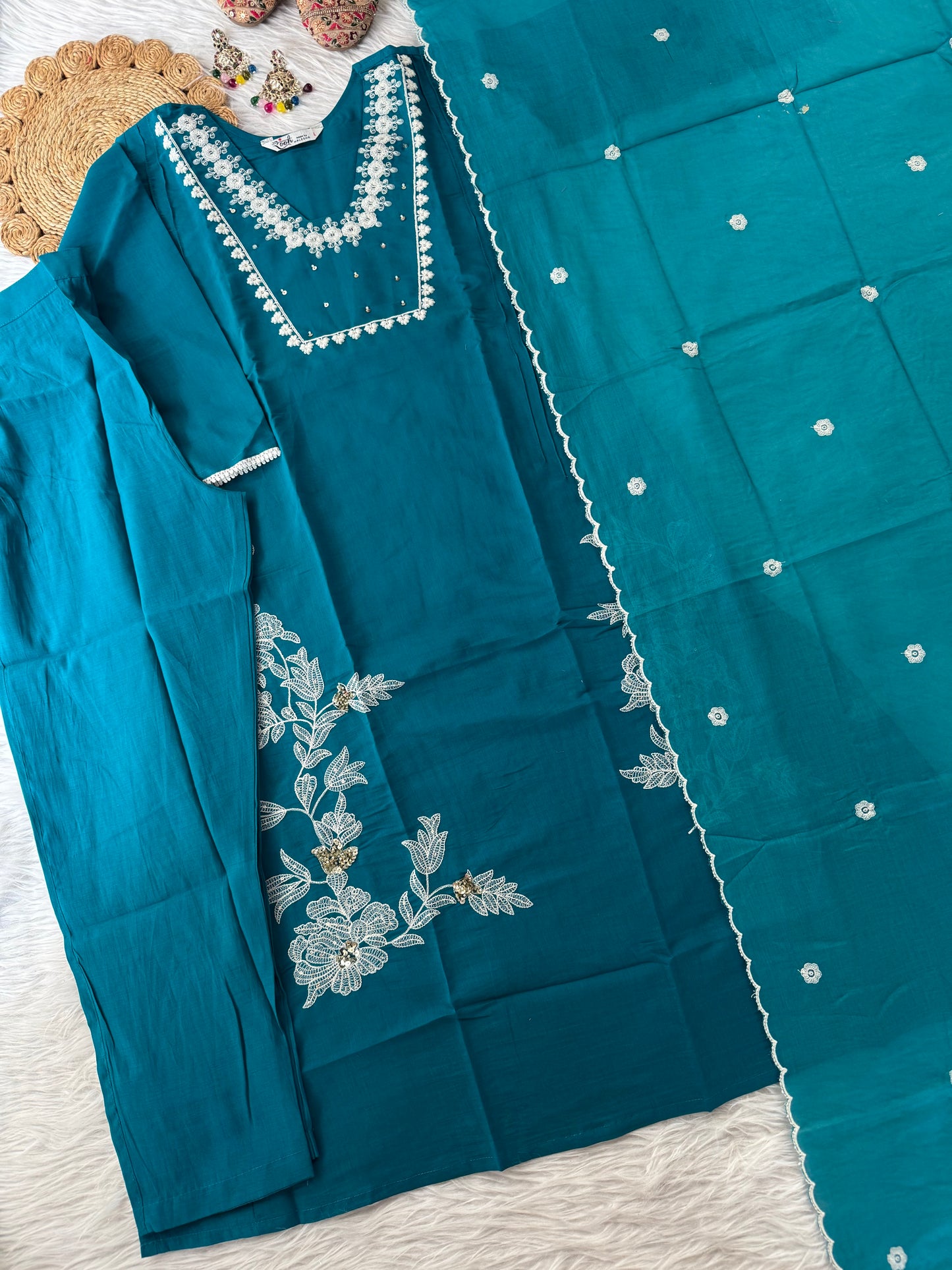 MD-195 This teal embroidered suit set, adorned with delicate floral motifs and mirror accents, blends tradition with elegance — perfect for festive gatherings or serene daytime soirees."