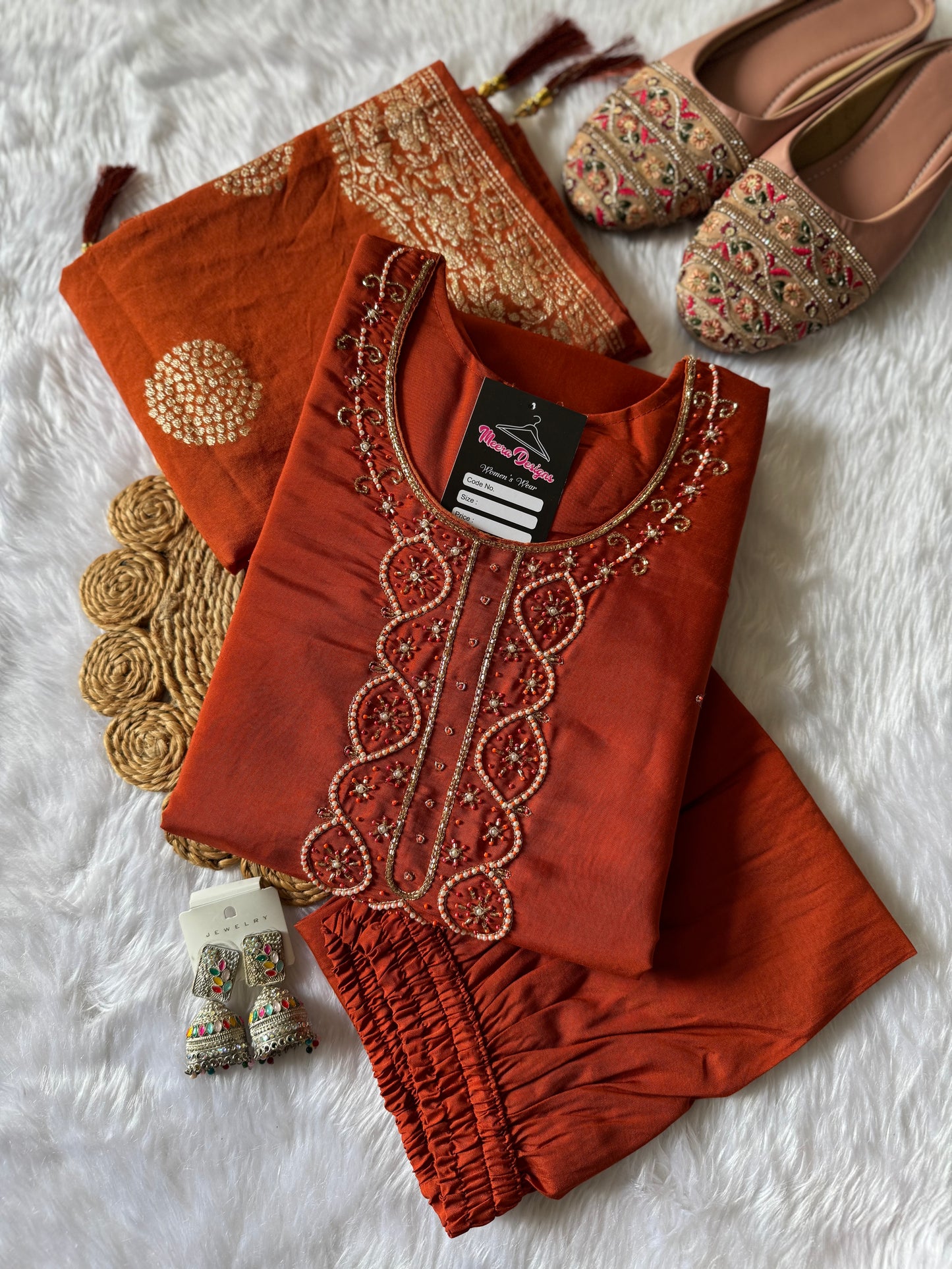 MD-176 This rust orange ethnic set, adorned with delicate embroidery and a touch of golden elegance, is your perfect pick for festive flair and timeless charm."
