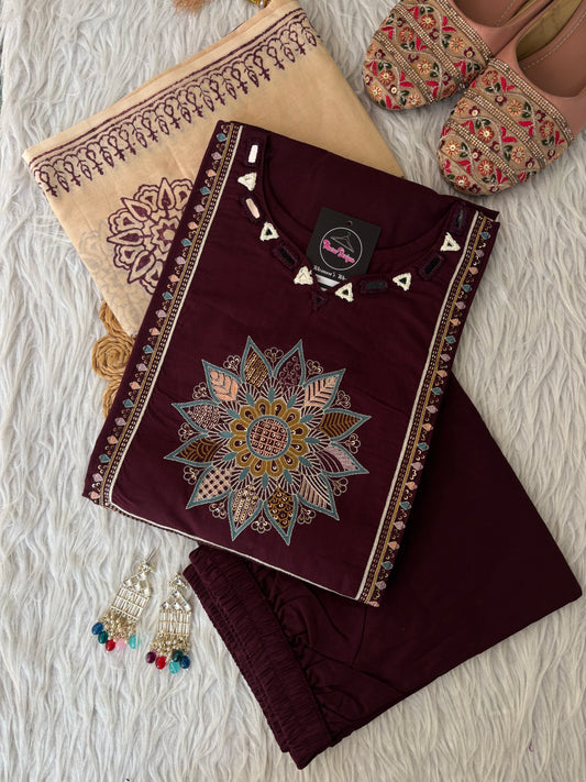 MD-265 This elegant three-piece ethnic set features a deep Kurti and matching trousers, paired with a contrasting cream-colored Dupatta. The ensemble balances rich, solid tones with intricate traditional detailing, making it ideal for festive