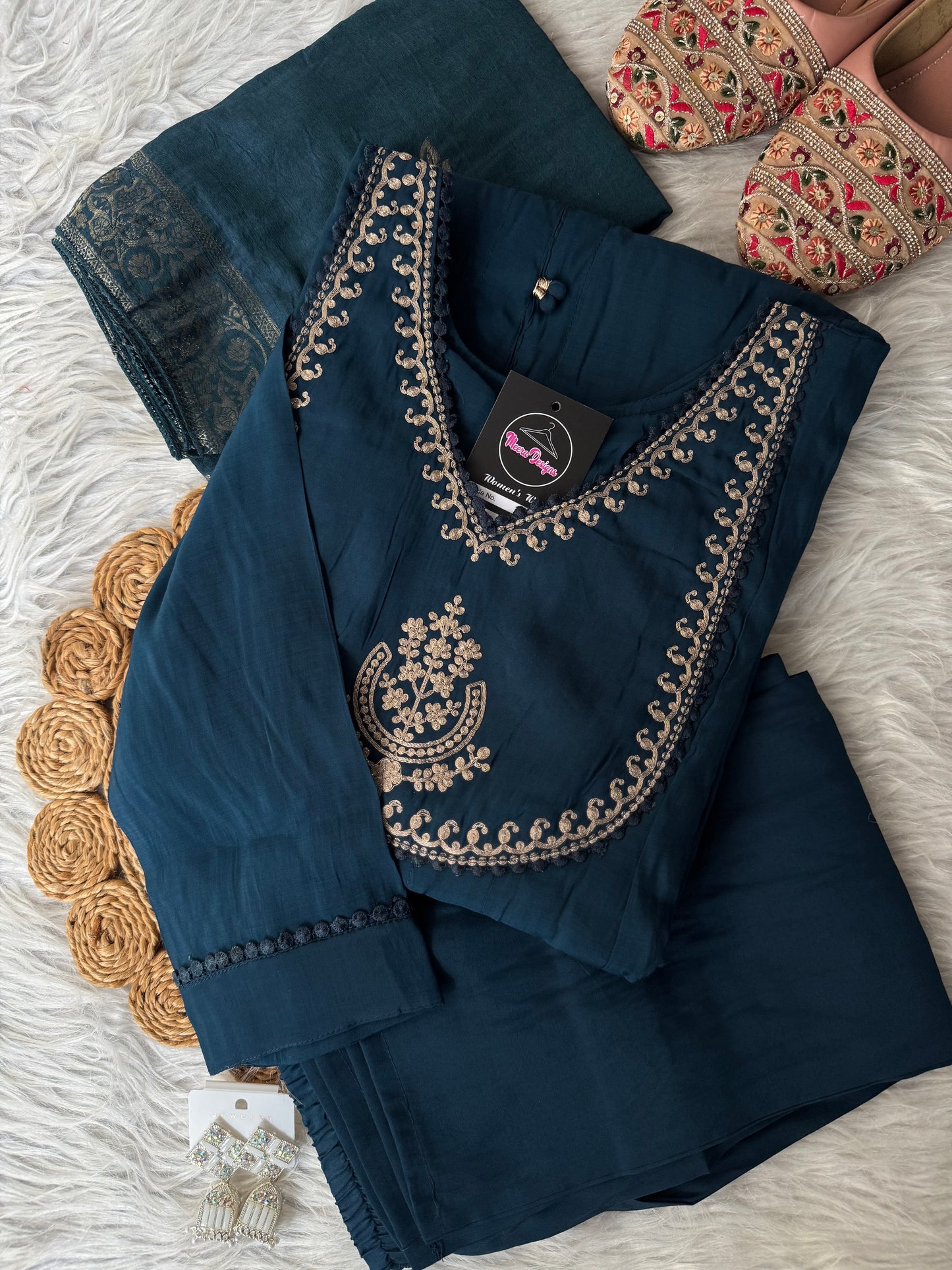 MD-201 Elegant deep teal ethnic ensemble featuring a flared kurta with delicate mirror buttons and intricate golden embroidery on the neckline, paired with matching pants and a rich, woven dupatta adorned with subtle floral motifs. Perfect for festive occ