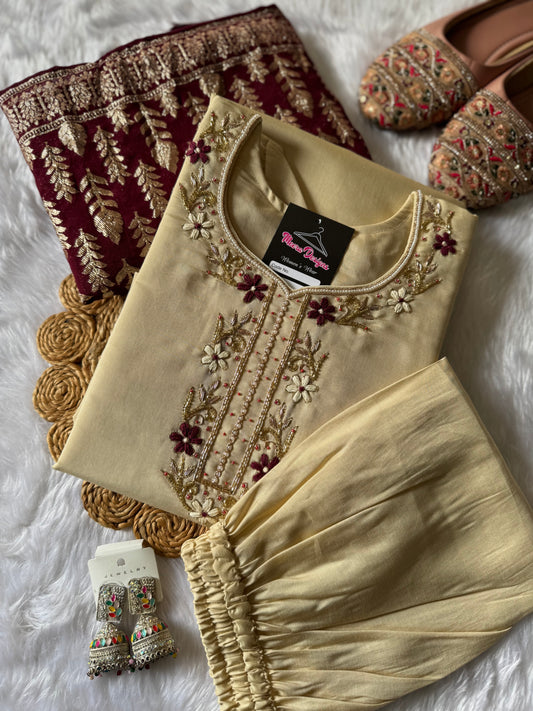 MD-177 this pastel cream white suit set, adorned with delicate floral embroidery, is perfectly paired with a rich maroon dupatta featuring golden motifs. A timeless ensemble for graceful festive moments. ✨🌸