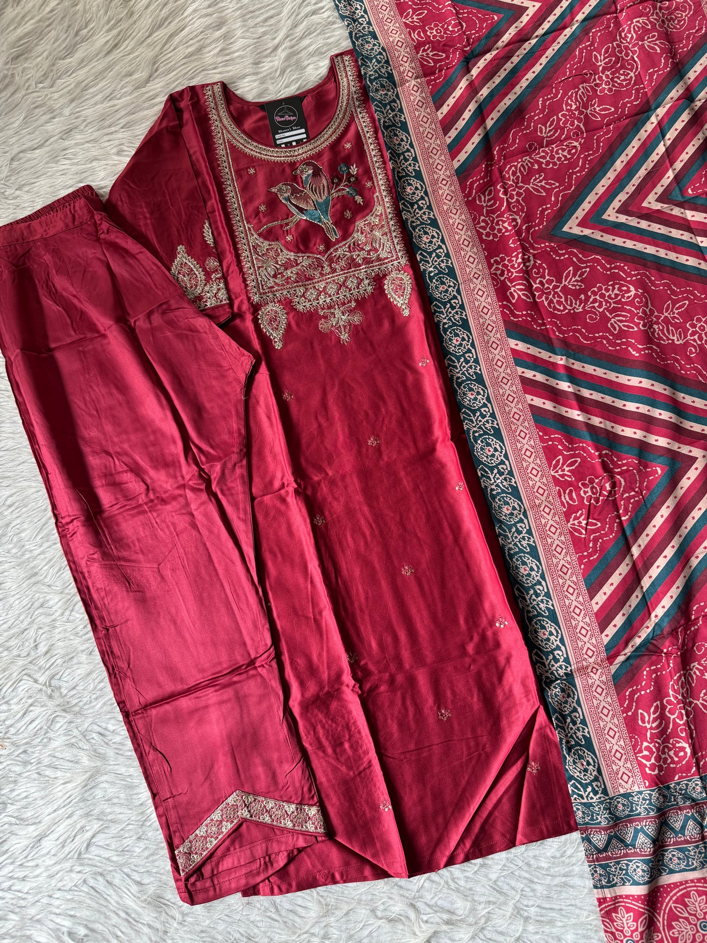 MD-202 Elegant traditional outfit featuring intricate embroidery with a charming bird motif on the neckline. Paired with matching trousers and a beautifully patterned dupatta, this ensemble blends nature-inspired art with classic style for a g
