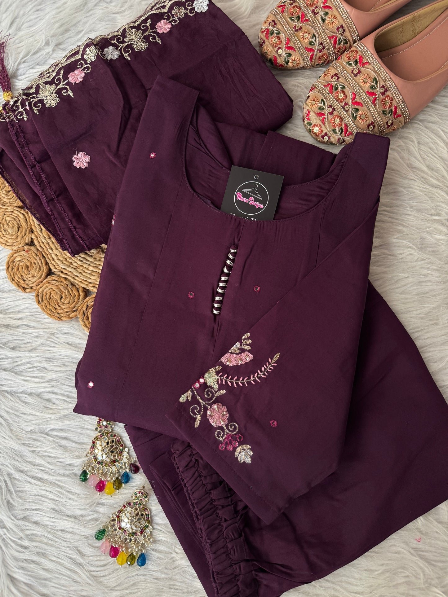 MD-194 "Unveil timeless grace in this deep plum ethnic suit, adorned with intricate floral embroidery in soft pinks and greens. Perfectly balanced between elegance and tradition, it’s a wardrobe essential for festive moments."