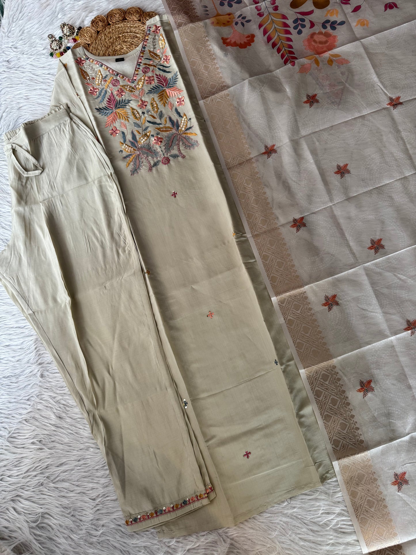 MD-192 This elegant beige suit set features exquisite thread and sequin embroidery on the neckline, paired with subtle mirror detailing and a woven dupatta adorned with delicate motifs — a timeless blend of tradition and charm."