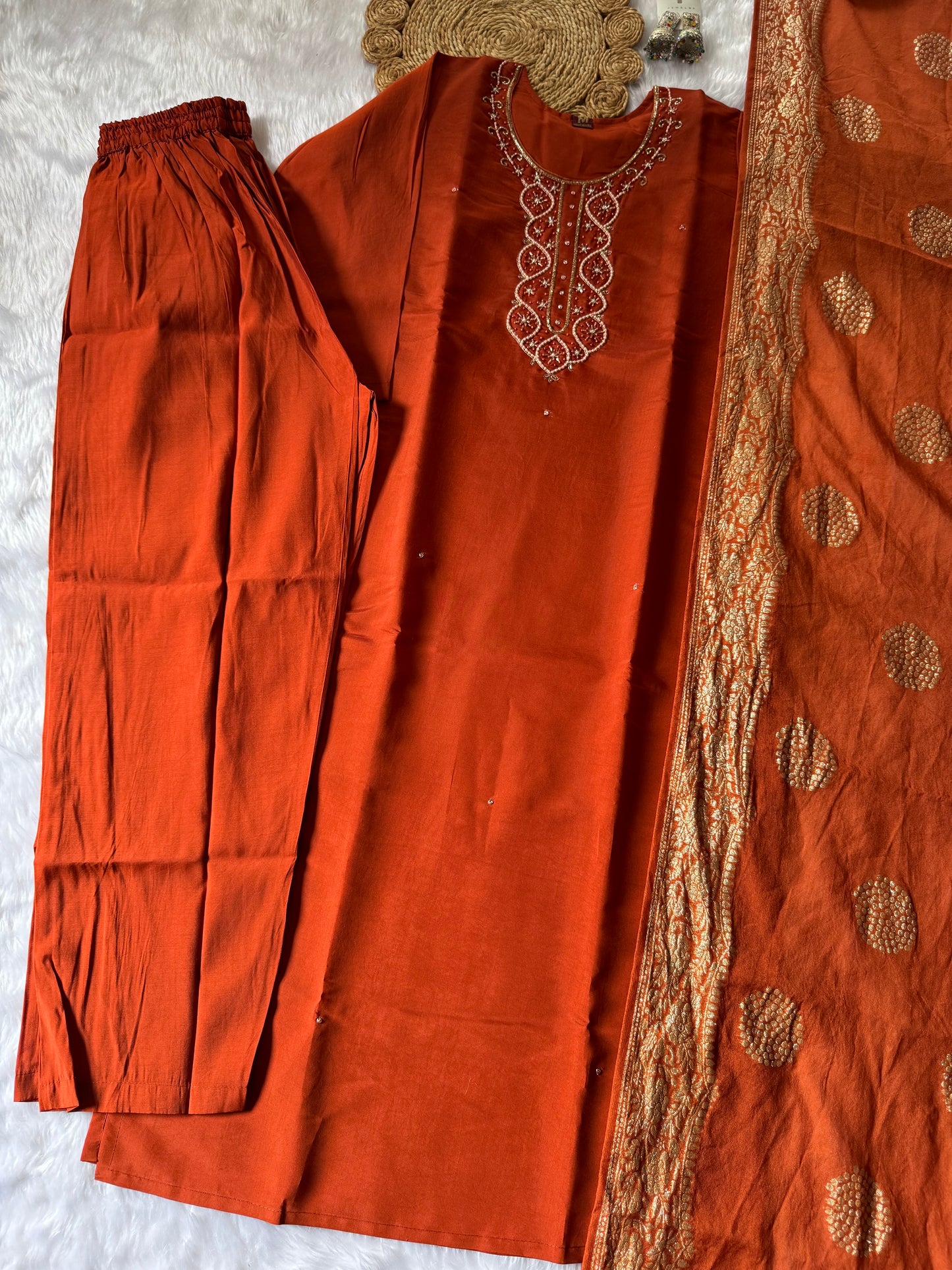 MD-176 This rust orange ethnic set, adorned with delicate embroidery and a touch of golden elegance, is your perfect pick for festive flair and timeless charm."