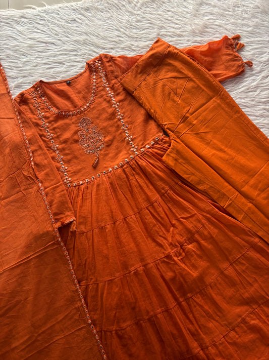 MD-263 This outfit is a vibrant tiered Anarkali suit set, likely crafted from a breathable cotton or cotton-slub fabric. It blends traditional Indian ethnic wear with a modern, breezy silhouette.