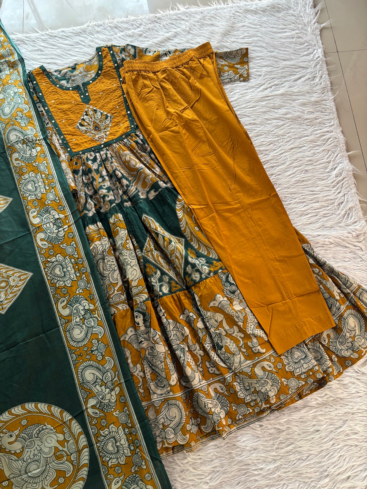 MD-273 "Embracing timeless tradition with a modern twist. Loving the rich hues, intricate Kalamkari-inspired prints, and delicate mirror work on this gorgeous tiered suit set. ✨💛"
