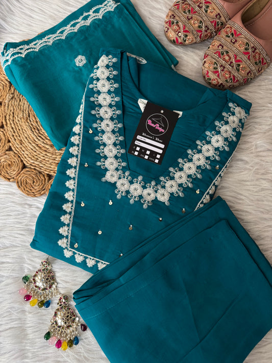 MD-195 This teal embroidered suit set, adorned with delicate floral motifs and mirror accents, blends tradition with elegance — perfect for festive gatherings or serene daytime soirees."