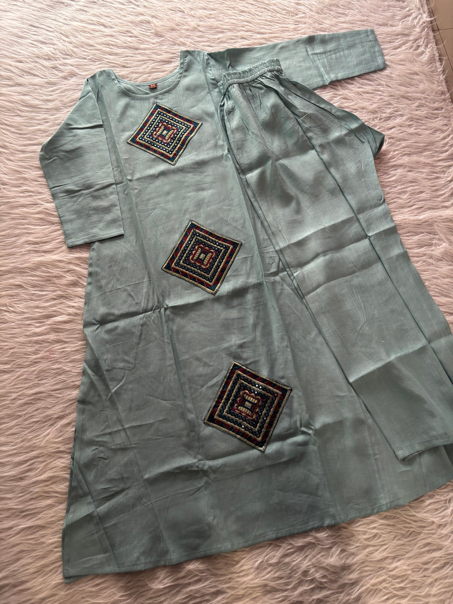 MD-234 This kurta set features striking geometric patchwork, blending traditional craftsmanship with a clean, contemporary silhouette. Perfect for those who appreciate the beauty of subtle details.