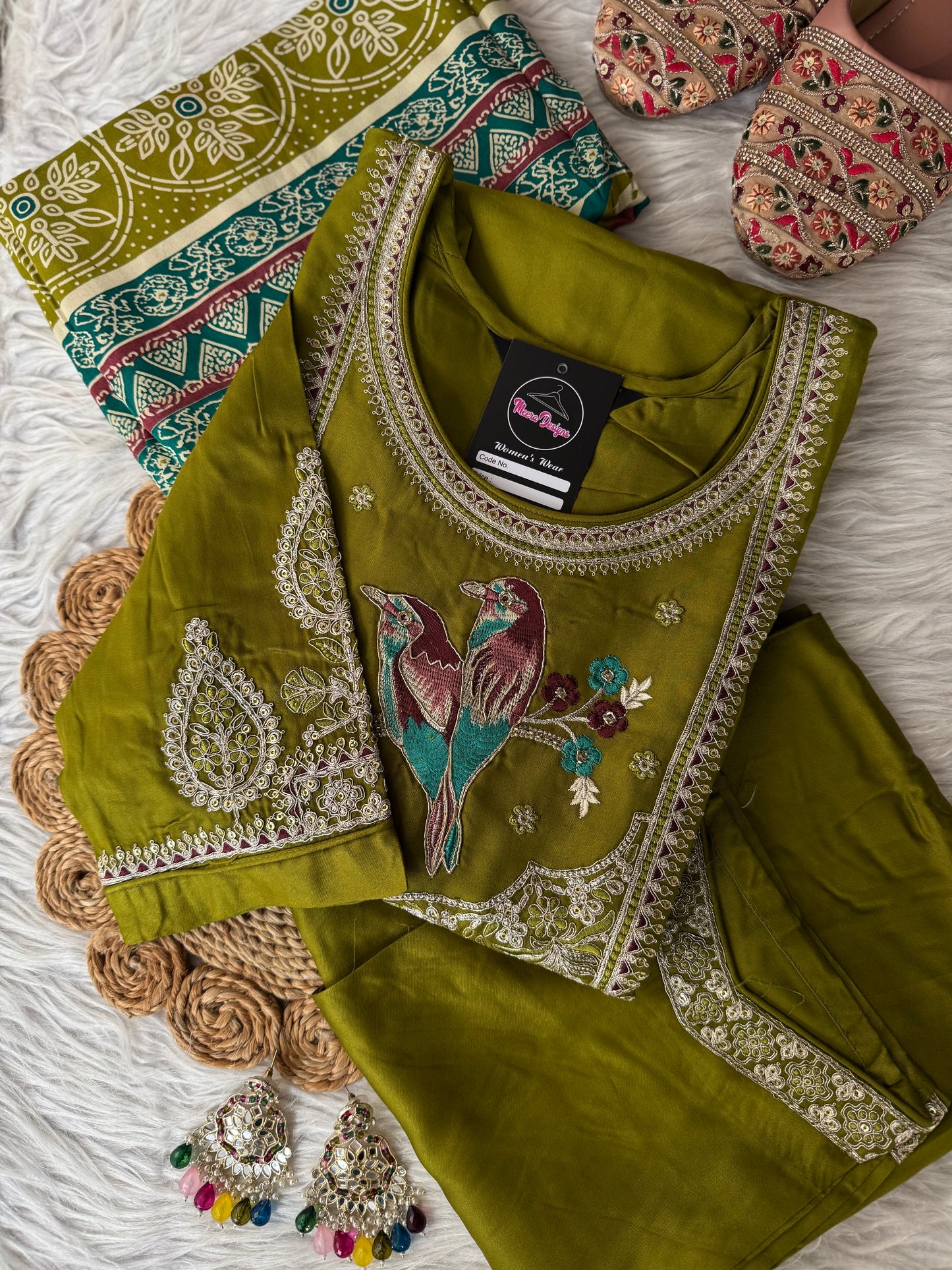 MD-202 Elegant traditional outfit featuring intricate embroidery with a charming bird motif on the neckline. Paired with matching trousers and a beautifully patterned dupatta, this ensemble blends nature-inspired art with classic style for a g