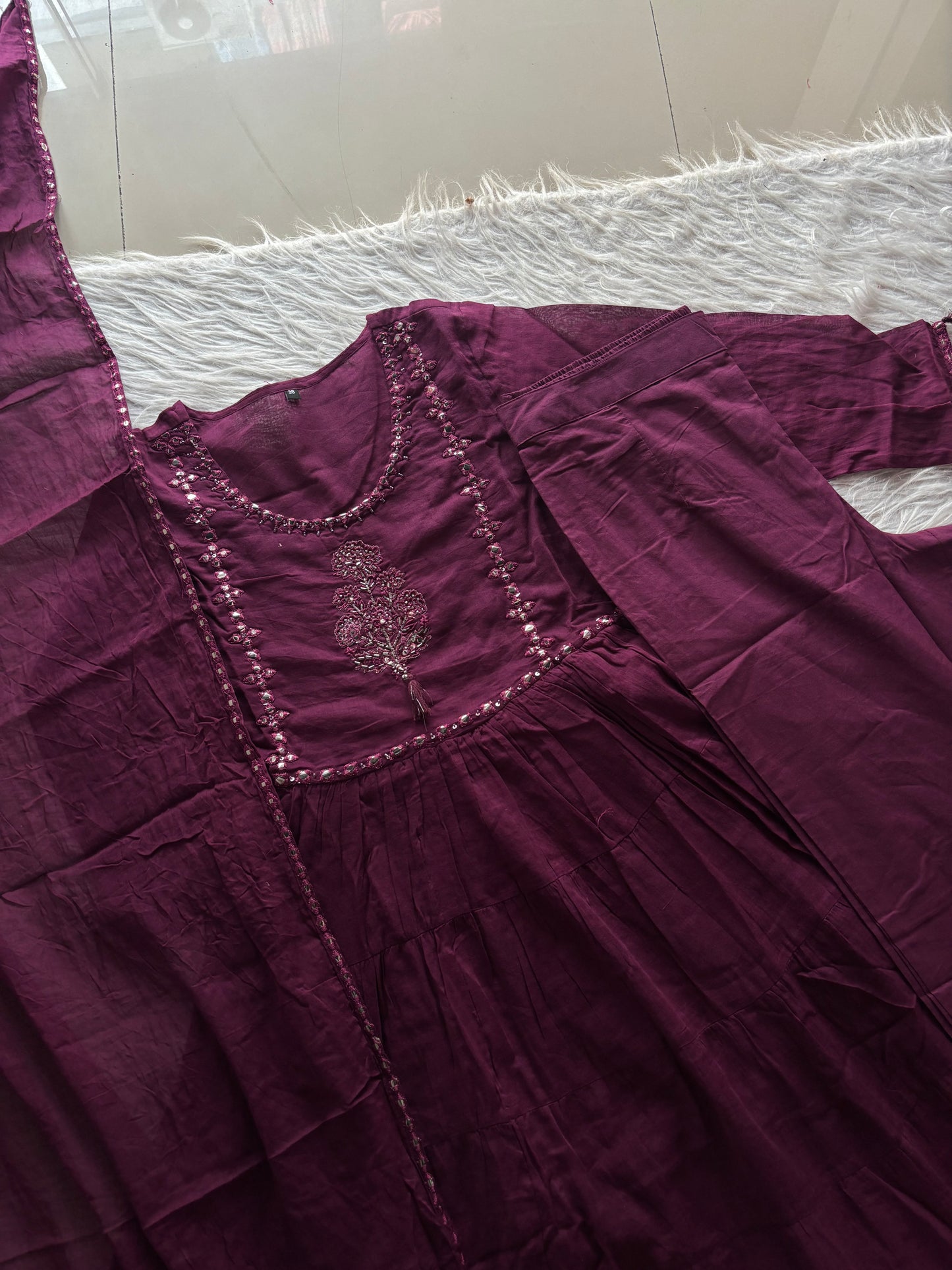 MD-262 This outfit is a vibrant tiered Anarkali suit set, likely crafted from a breathable cotton or cotton-slub fabric. It blends traditional Indian ethnic wear with a modern, breezy silhouette.