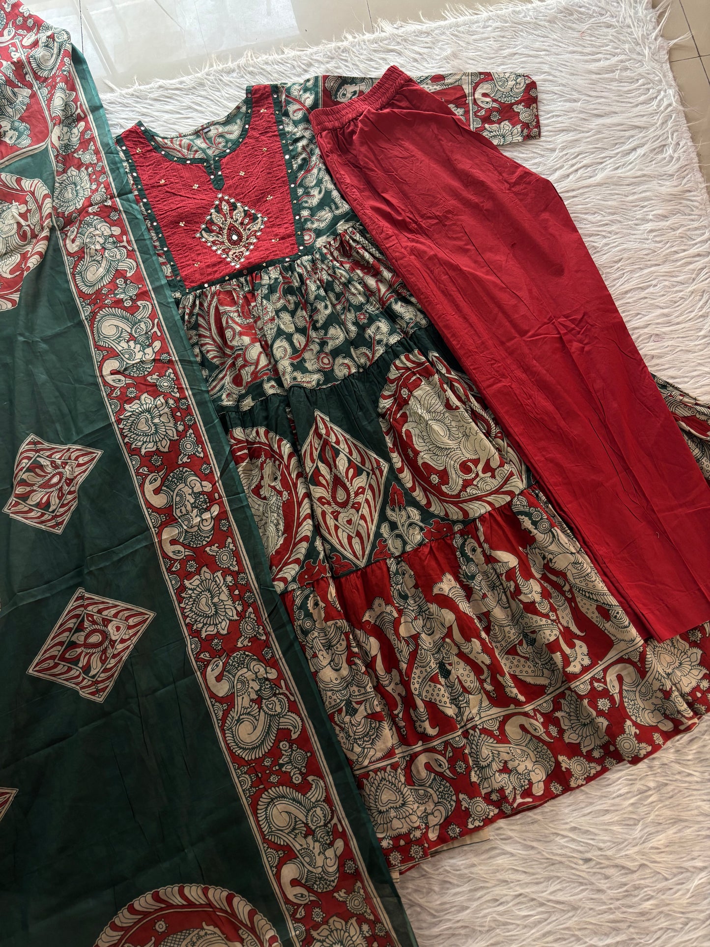 MD-273 "Embracing timeless tradition with a modern twist. Loving the rich hues, intricate Kalamkari-inspired prints, and delicate mirror work on this gorgeous tiered suit set. ✨💛"